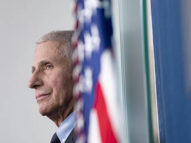 Dr. Anthony Fauci watches on during a press conference